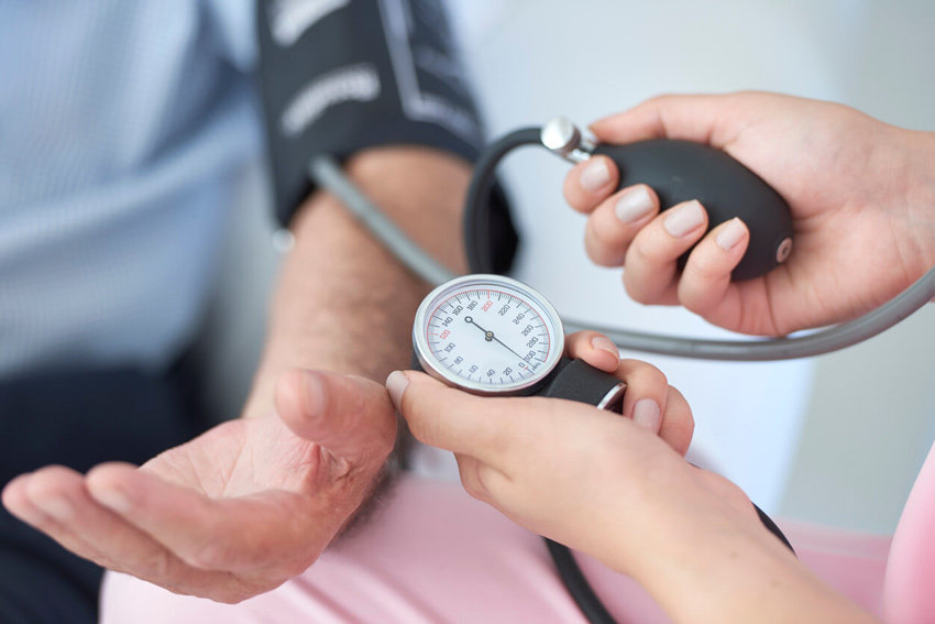 Doctor checking the blood pressure of a sleep apnea patient in a followup visit after prescribing oral appliance therapy