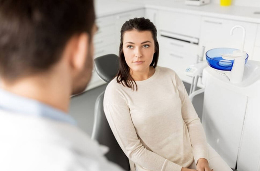 A young woman and her dentist discuss oral appliance treatment for her sleep apnea